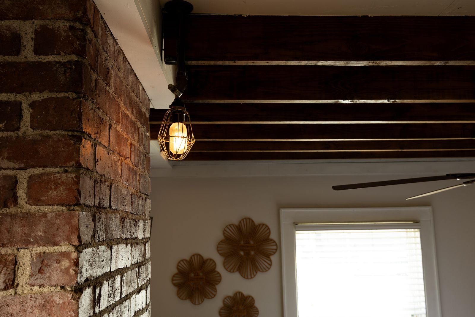 Old brick chimney and a caged lamp under dark beams