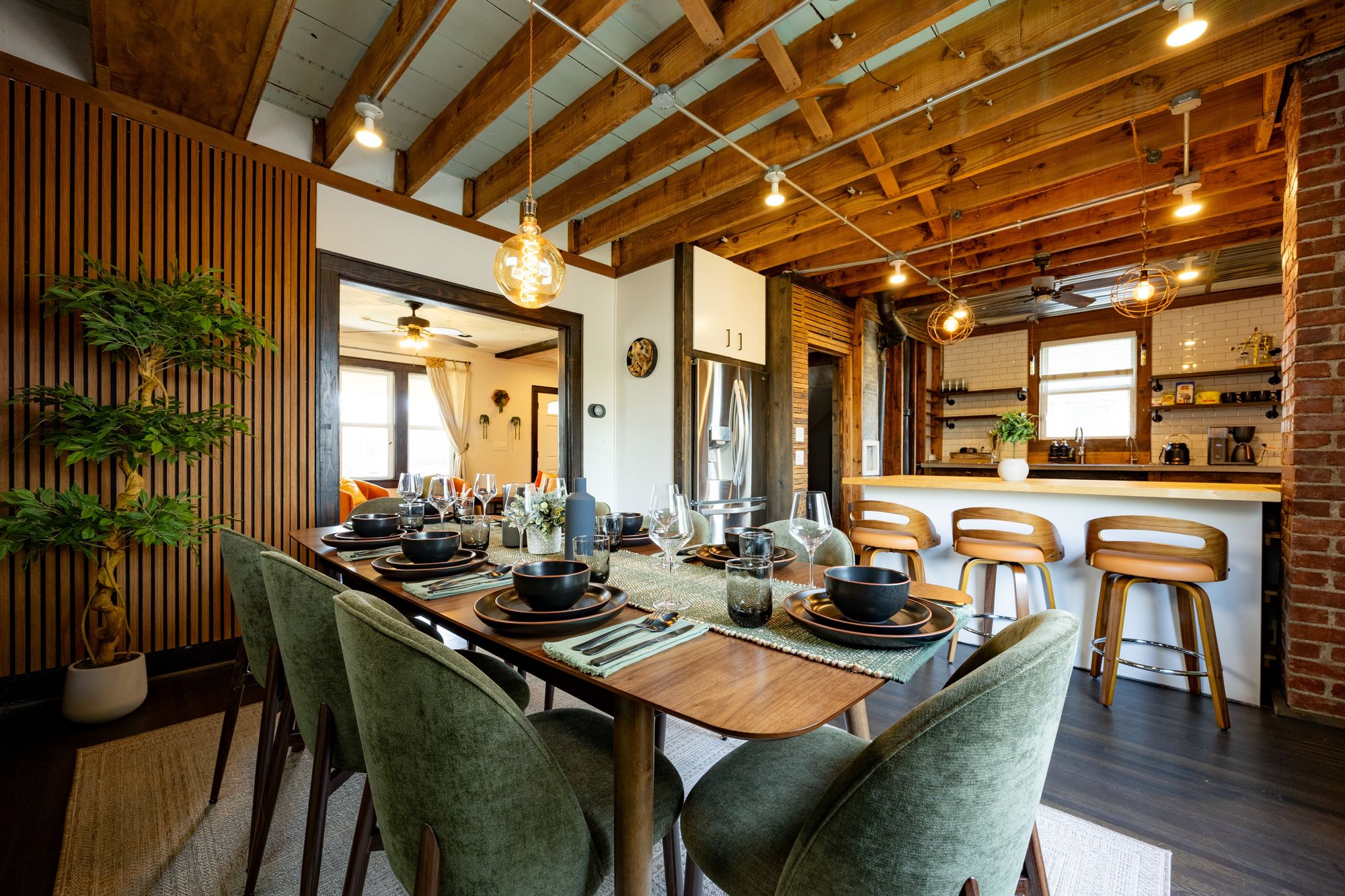 Dining table and kitchen under exposed wood beams